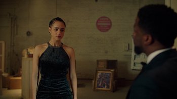 Movie still from “Die Hart” (2023), directed by Eric Appel – A woman in a black dress standing in front of a man; Medium shot, Over the shoulder angle