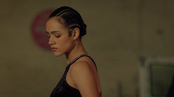 Movie still from “Die Hart” (2023), directed by Eric Appel – A woman with a black dress and a black necklace; Close Up shot, Low angle