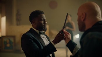 Movie still from “Die Hart” (2023), directed by Eric Appel – A man in a tuxedo is holding a pair of scissors; Close Up shot, Over the shoulder angle