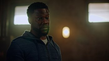 Movie still from “Die Hart” (2023), directed by Eric Appel – A person wearing a jacket; Close Up shot, Over the shoulder angle