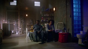 Movie still from “Die Hart” (2023), directed by Eric Appel – Two people sitting on a bed in a room; Wide shot, High angle