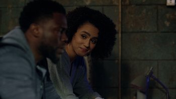 Movie still from “Die Hart” (2023), directed by Eric Appel – A woman sitting next to a man in a dark room; Close Up shot, Over the shoulder angle