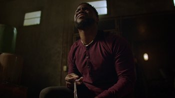 Movie still from “Die Hart” (2023), directed by Eric Appel – A man sitting in a dark room holding a toothbrush in his mouth; Close Up shot, Low angle