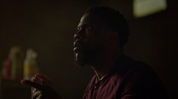 Movie still from “Die Hart” (2023), directed by Eric Appel – A man with a beard is sitting in a dark room; Close Up shot, Low angle
