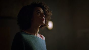 Movie still from “Die Hart” (2023), directed by Eric Appel – A woman with curly hair looking up at the sky; Close Up shot, Low angle