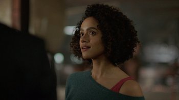 Movie still from “Die Hart” (2023), directed by Eric Appel – A woman with curly hair is looking to her left; Close Up shot, Over the shoulder angle