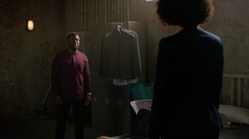 Movie still from “Die Hart” (2023), directed by Eric Appel – A man and a woman standing in front of a suit on a rack; Wide shot, Over the shoulder angle