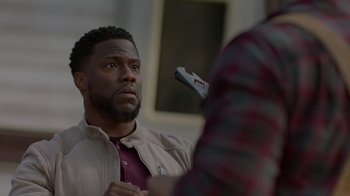 Movie still from “Die Hart” (2023), directed by Eric Appel – A person holding a cell phone; Close Up shot, Over the shoulder angle