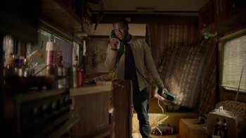 Movie still from “Die Hart” (2023), directed by Eric Appel – A man standing in a room holding a nintendo wii controller; Medium shot, High angle