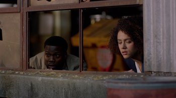 Movie still from “Die Hart” (2023), directed by Eric Appel – A man and a woman looking out of a window; Medium shot, High angle