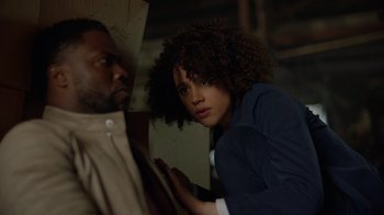 Movie still from “Die Hart” (2023), directed by Eric Appel – A man and a woman standing next to each other; Medium shot, Over the shoulder angle