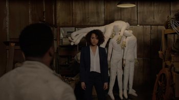 Movie still from “Die Hart” (2023), directed by Eric Appel – A woman standing in front of a group of mannequins; Wide shot, Over the shoulder angle