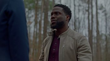 Movie still from “Die Hart” (2023), directed by Eric Appel – A man in a brown jacket standing next to a tree; Close Up shot, Over the shoulder angle