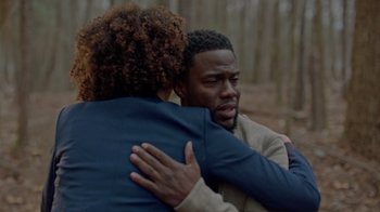 Movie still from “Die Hart” (2023), directed by Eric Appel – Two people hugging in a wooded area; Medium shot, Over the shoulder angle
