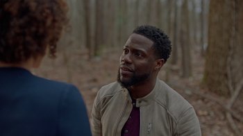 Movie still from “Die Hart” (2023), directed by Eric Appel – A man in a brown jacket talking to another man; Close Up shot, Over the shoulder angle