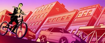 Movie still from “Die in a Gunfight” (2021), directed by Collin Schiffli – Cars parked on the side of the road in front of a building; Extreme Wide shot, Low angle