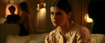 Movie still from “Die in a Gunfight” (2021), directed by Collin Schiffli – A beautiful young lady sitting on a couch; Close Up shot, Over the shoulder angle