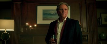 Movie still from “Die in a Gunfight” (2021), directed by Collin Schiffli – An older man holding a wine glass in his hand; Close Up shot, Low angle