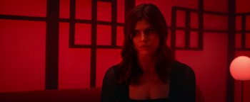 Movie still from “Die in a Gunfight” (2021), directed by Collin Schiffli – A woman in a black shirt is in a red room; Close Up shot, Low angle