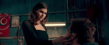 Movie still from “Die in a Gunfight” (2021), directed by Collin Schiffli – A woman standing in front of a man touching his ear; Close Up shot, Low angle