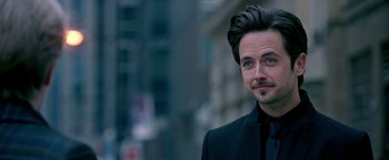 Movie still from “Die in a Gunfight” (2021), directed by Collin Schiffli – A person wearing a suit and tie; Close Up shot, Over the shoulder angle