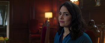 Movie still from “Die in a Gunfight” (2021), directed by Collin Schiffli – A woman in a blue shirt is looking at the camera; Close Up shot, Over the shoulder angle