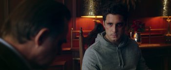 Movie still from “Die in a Gunfight” (2021), directed by Collin Schiffli – A man sitting in a chair in front of a lamp; Close Up shot, Over the shoulder angle