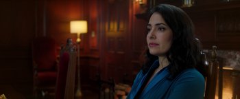 Movie still from “Die in a Gunfight” (2021), directed by Collin Schiffli – A woman in a blue shirt is looking at the camera; Close Up shot, Over the shoulder angle