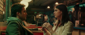 Movie still from “Die in a Gunfight” (2021), directed by Collin Schiffli – A man and a woman holding hands in a restaurant; Medium shot, Low angle