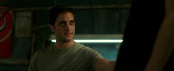 Movie still from “Die in a Gunfight” (2021), directed by Collin Schiffli – A young man with red eyes looking into the distance; Close Up shot, Over the shoulder angle