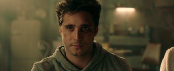 Movie still from “Die in a Gunfight” (2021), directed by Collin Schiffli – A person wearing a hoodie; Close Up shot, Over the shoulder angle