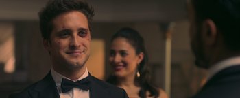 Movie still from “Die in a Gunfight” (2021), directed by Collin Schiffli – A young man and a young woman are posing for a picture; Close Up shot, Over the shoulder angle