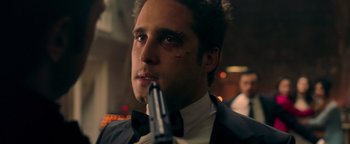 Movie still from “Die in a Gunfight” (2021), directed by Collin Schiffli – A person holding a gun; Close Up shot, Over the shoulder angle