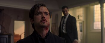 Movie still from “Die in a Gunfight” (2021), directed by Collin Schiffli – Two men in suits and one is bleeding from his face; Close Up shot, Low angle
