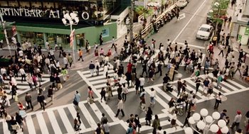 Movie still from “War of the Worlds” (2005), directed by Steven Spielberg – A group of people crossing a street in a crosswalk; Extreme Wide shot, Overhead angle