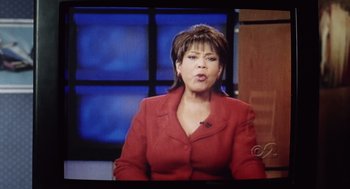 Movie still from “War of the Worlds” (2005), directed by Steven Spielberg – A woman in a red jacket is talking on a television; Close Up shot, Low angle