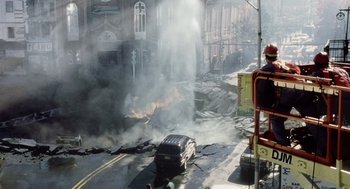 Movie still from “War of the Worlds” (2005), directed by Steven Spielberg – A car that is on fire in the middle of the street; Extreme Wide shot, High angle