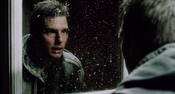 Movie still from “War of the Worlds” (2005), directed by Steven Spielberg – A man looking at himself in the mirror; Close Up shot, Over the shoulder angle