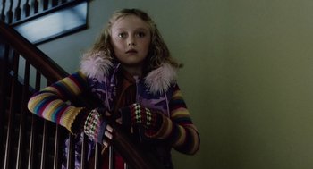 Movie still from “War of the Worlds” (2005), directed by Steven Spielberg – A young girl in a colorful jacket holding a fence; Medium shot, Low angle