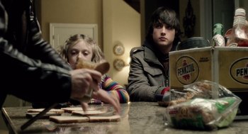 Movie still from “War of the Worlds” (2005), directed by Steven Spielberg – Two people sitting at a table eating food; Medium shot, Over the shoulder angle