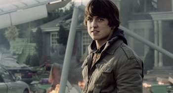 Movie still from “War of the Worlds” (2005), directed by Steven Spielberg – A young man standing in front of a burning house; Close Up shot, Over the shoulder angle