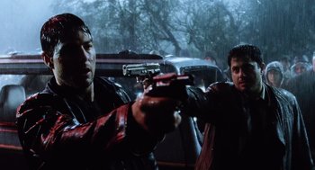 Movie still from “War of the Worlds” (2005), directed by Steven Spielberg – Two men in leather jackets holding guns in a car; Medium shot, Low angle