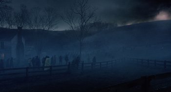 Movie still from “War of the Worlds” (2005), directed by Steven Spielberg – A group of people standing in a field at night; Extreme Wide shot, High angle