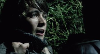 Movie still from “War of the Worlds” (2005), directed by Steven Spielberg – A young man holding a pair of shoes in his hands; Close Up shot, High angle