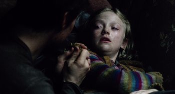 Movie still from “War of the Worlds” (2005), directed by Steven Spielberg – A person holding a child's hand while they both look sad; Close Up shot, High angle