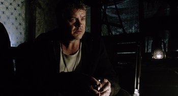 Movie still from “War of the Worlds” (2005), directed by Steven Spielberg – A man sitting in the dark with a cigarette in his mouth; Close Up shot, Low angle