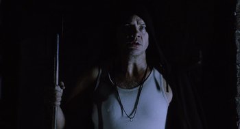 Movie still from “War of the Worlds” (2005), directed by Steven Spielberg – A man in a white tank top holding a stick; Close Up shot, Low angle