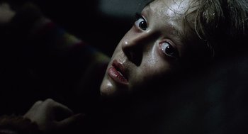 Movie still from “War of the Worlds” (2005), directed by Steven Spielberg – A young girl with dark eyes stares into the camera; Close Up shot, Low angle