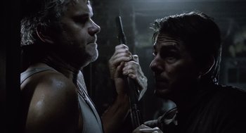 Movie still from “War of the Worlds” (2005), directed by Steven Spielberg – A man holding a gun in his hand while another man looks on; Close Up shot, Over the shoulder angle