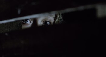 Movie still from “War of the Worlds” (2005), directed by Steven Spielberg – A young child's eyes are seen through a curtain; Extreme Close Up shot, Overhead angle